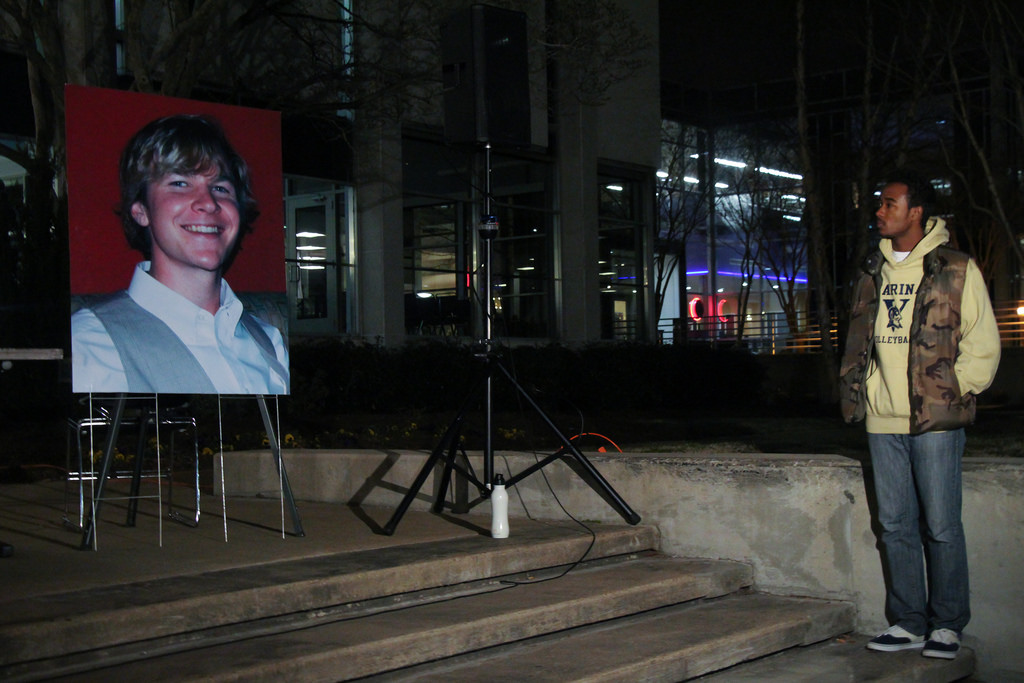 ODU student and former high school volleyball teammate, stands by the Paul Johnson blown portrait in memoir of his friend.